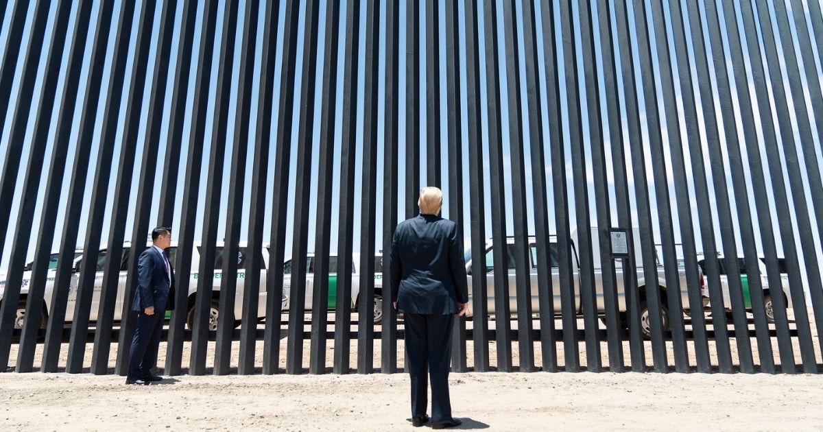 President Donald J. Trump stands before a plaque Tuesday, June 23, 2020, commemorating the 200th mile of new border wall along the U.S.-Mexico border near Yuma, Ariz. (Official White House Photo by Shealah Craighead)