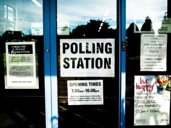 Polling station sign on a glass door