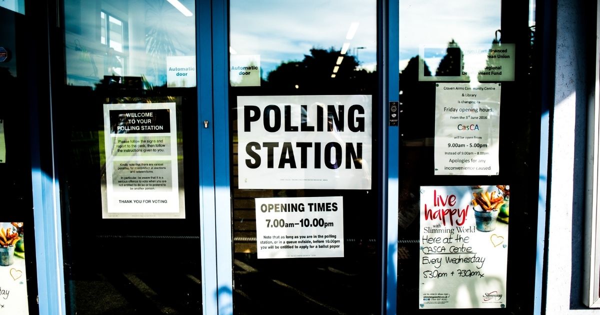 Polling station sign on a glass door