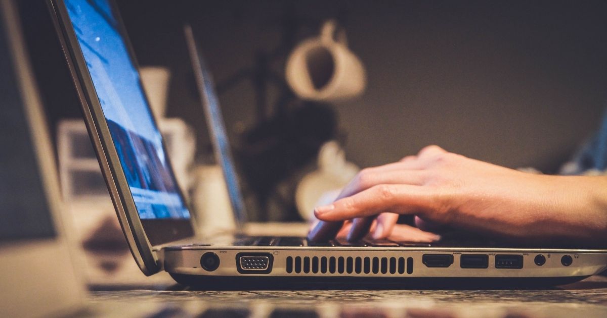 Person typing on silver laptop computer.