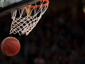 Basketball falling through a basketball hoop