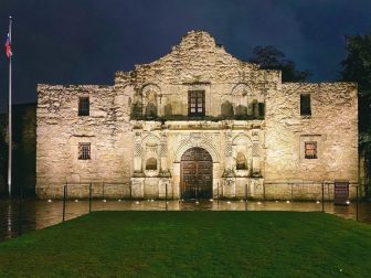 The Alamo in San Antonio, TX, lit up at night.