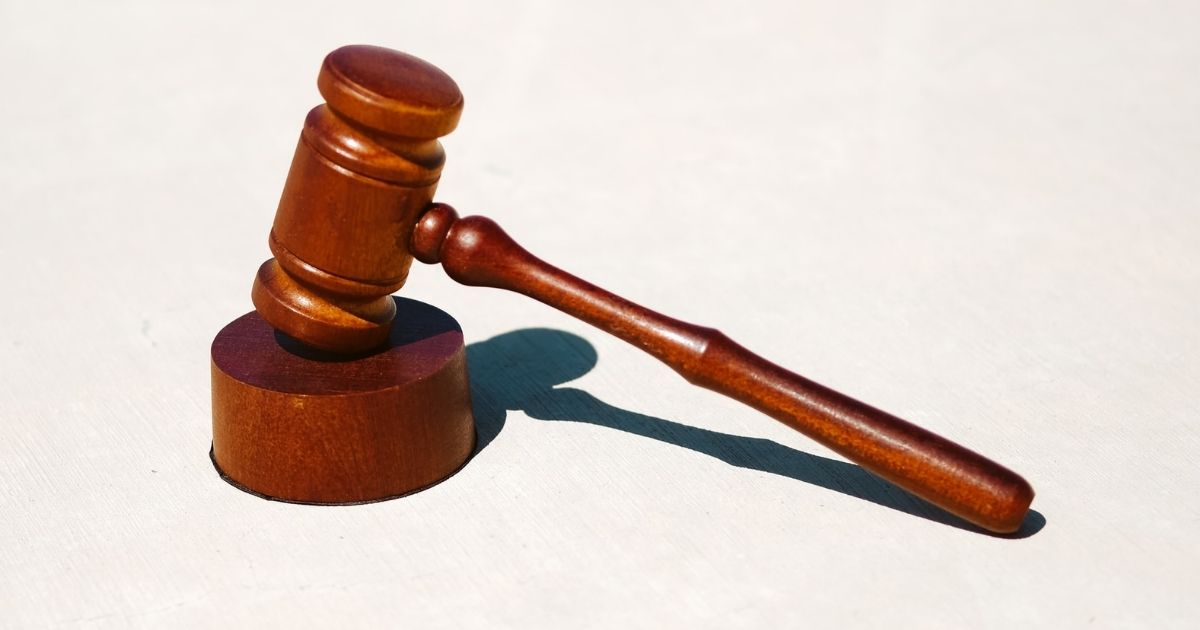 Brown wooden gavel on white surface