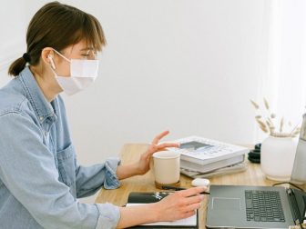 Woman wearing face mask while working from home