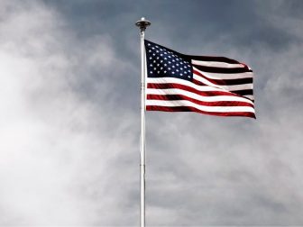 Waving USA flag under grey skies
