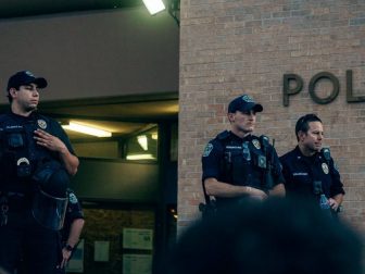 Image of police officers standing outside a police station.