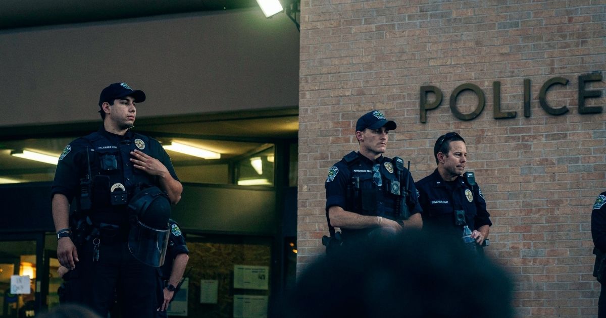 Image of police officers standing outside a police station.