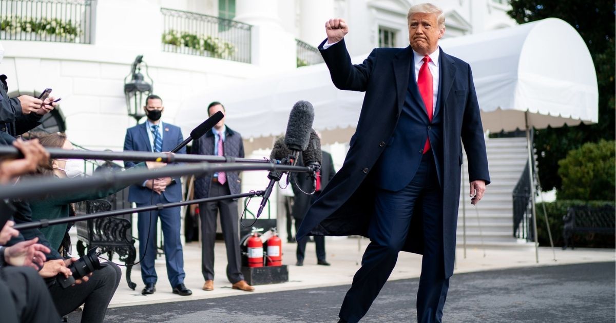 President Donald J. Trump gives a fist bump to the press Friday, Oct. 30, 2020, prior to boarding Marine One en route to Joint Base Andrews, Md. to begin his trip to Michigan, Wisconsin and Minnesota. (Official White House Photo by Tia Dufour)