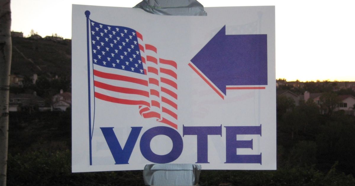 The above stock image shows a sign pointing to where people can go vote.