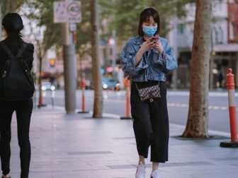 Woman in face mask walking down the street during a coronavirus lockdown