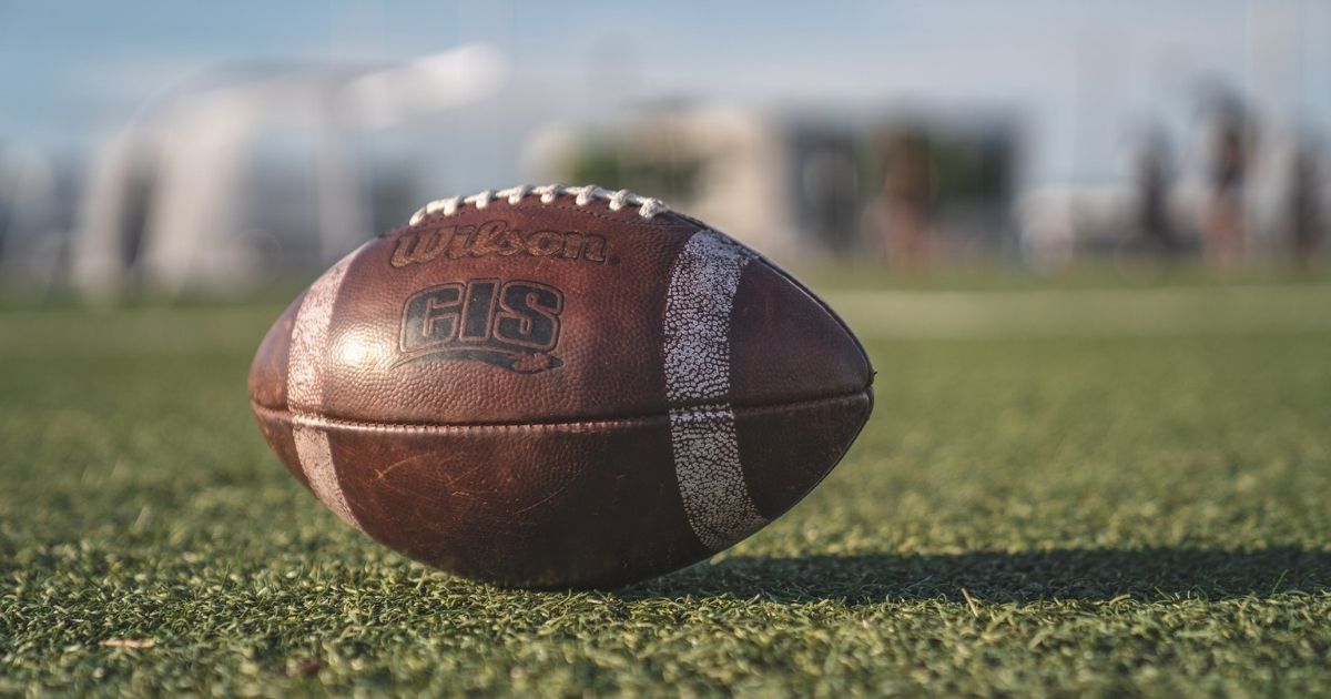 Selective focus close-up photo of brown Wilson pigskin football on green grass