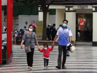 Family walking at Macau's Senado Square wearing protective face masks due to coronavirus (Covid-19) outbreak.