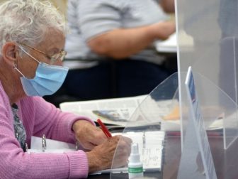 A woman works at the polls for Massachusetts state primary election on Sept. 1.