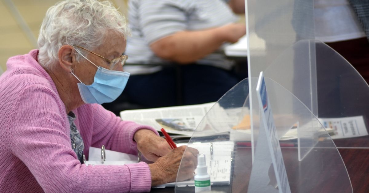 A woman works at the polls for Massachusetts state primary election on Sept. 1.