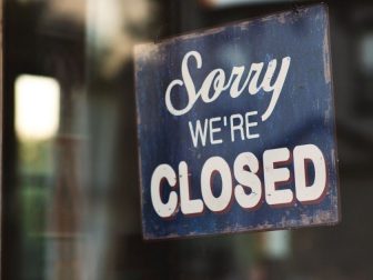 Closed sign hanging in window of storefront