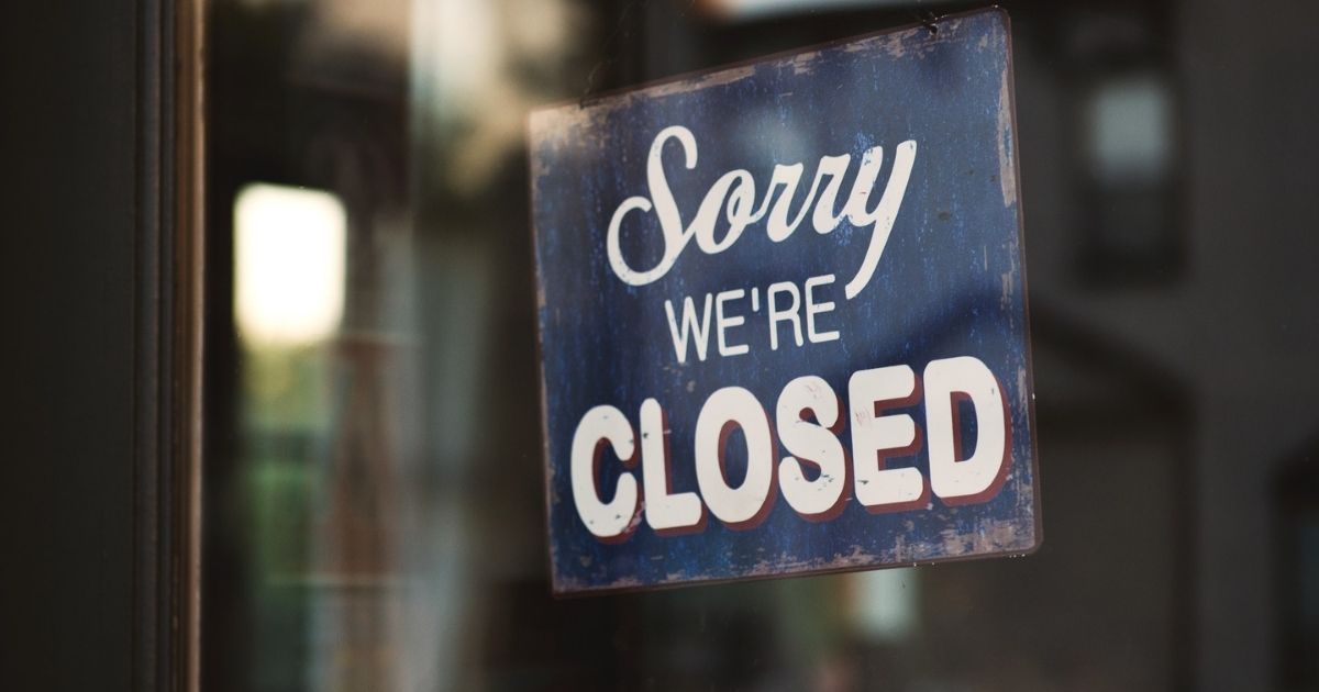 Closed sign hanging in window of storefront