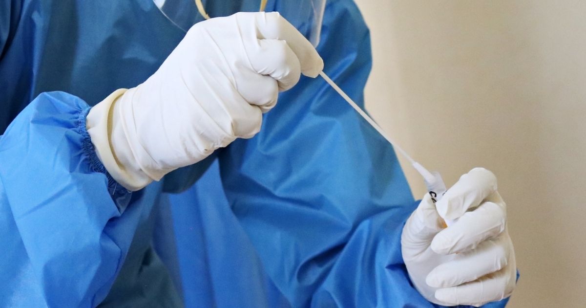 A laboratory worker takes a swab test