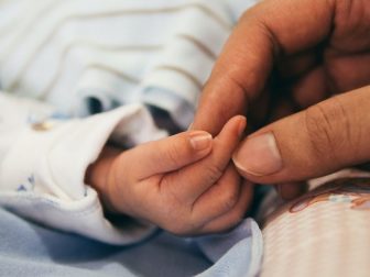 Person holding a baby's hand