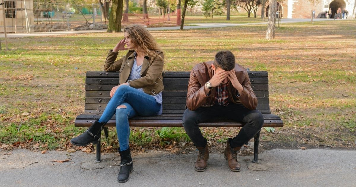 Frustrated man and woman sitting on a park bench