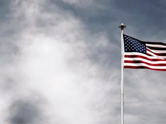 American flag flying against a cloudy sky