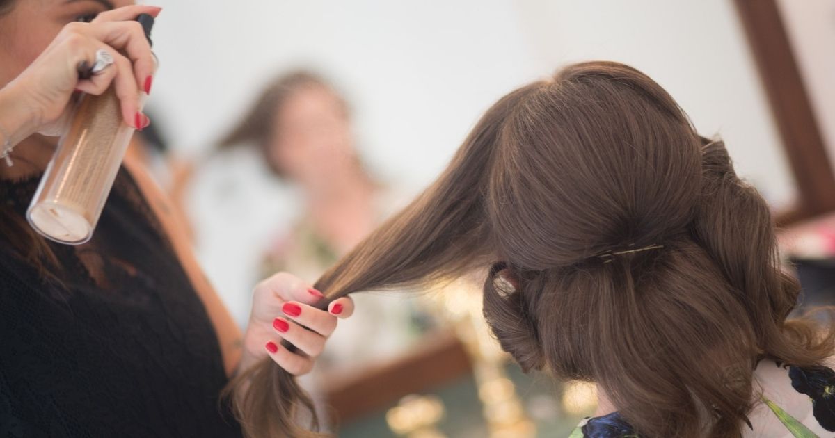 Woman styling hair of customer