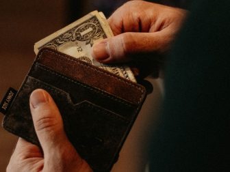 Hands pulling money out of a wallet