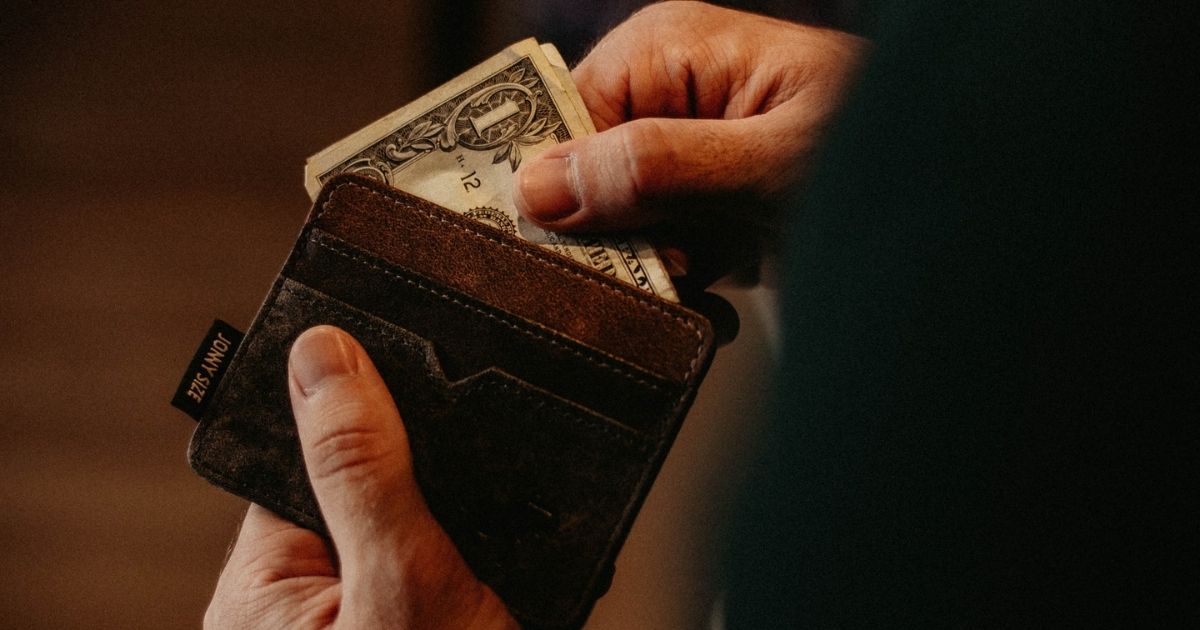 Hands pulling money out of a wallet
