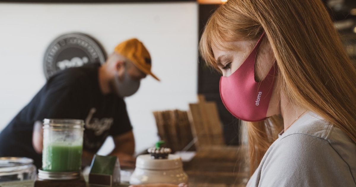 Man and woman working while wearing masks