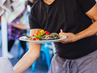 Waiter serving a plate of food