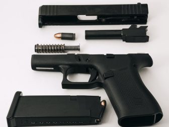 Disassembled Glock G43X (barrel, guide rod, and slide removed), loaded magazine, and 9mm round.