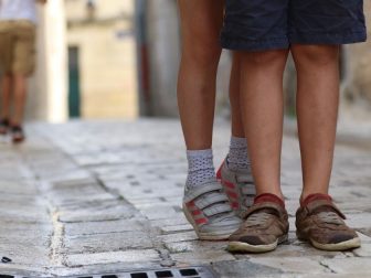 Shoes of a young boy and girl on a road.