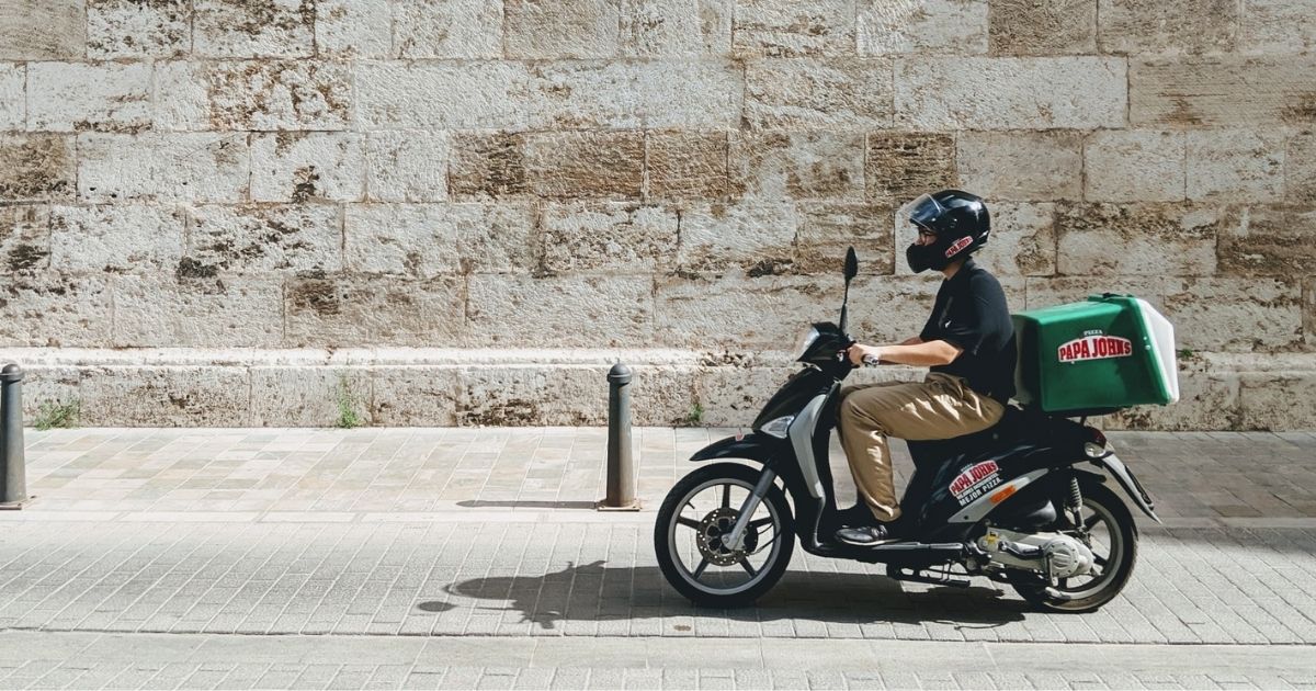 Delivery boy on the old streets of Valencia