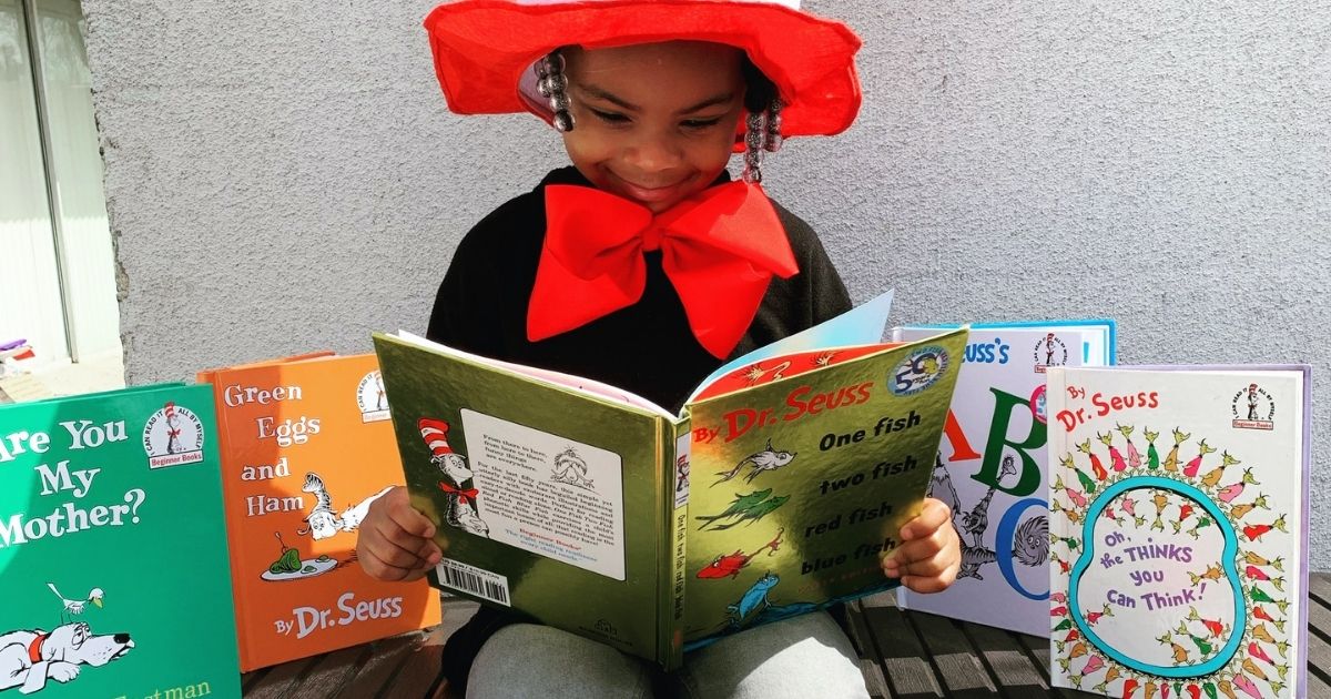 Girl reading Dr. Suess books