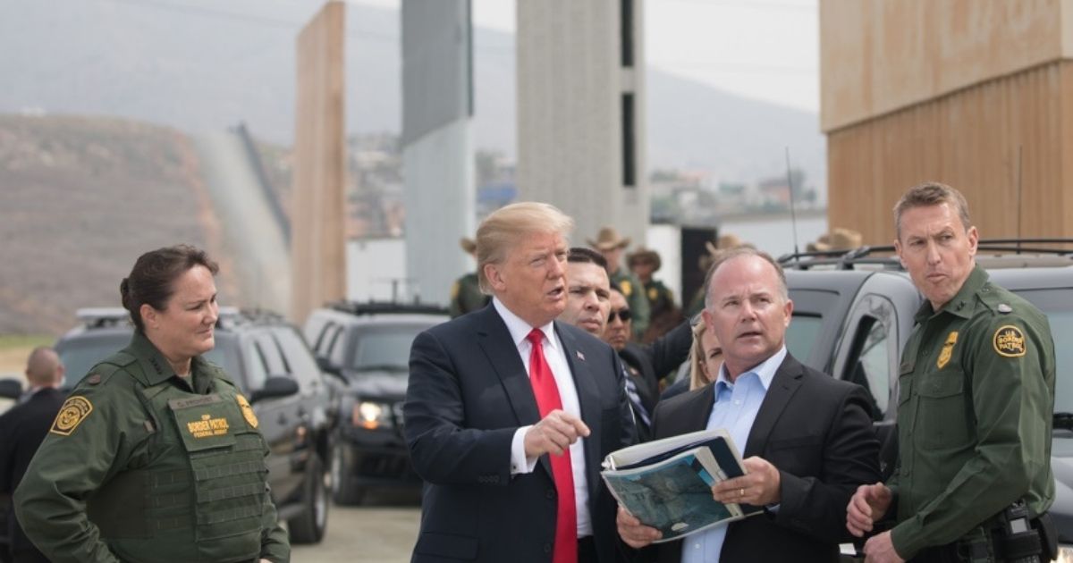 Then-President Donald Trump reviews U.S. Customs and Border Protection's wall prototypes on the border in Otay Mesa, California, on March 13, 2018.