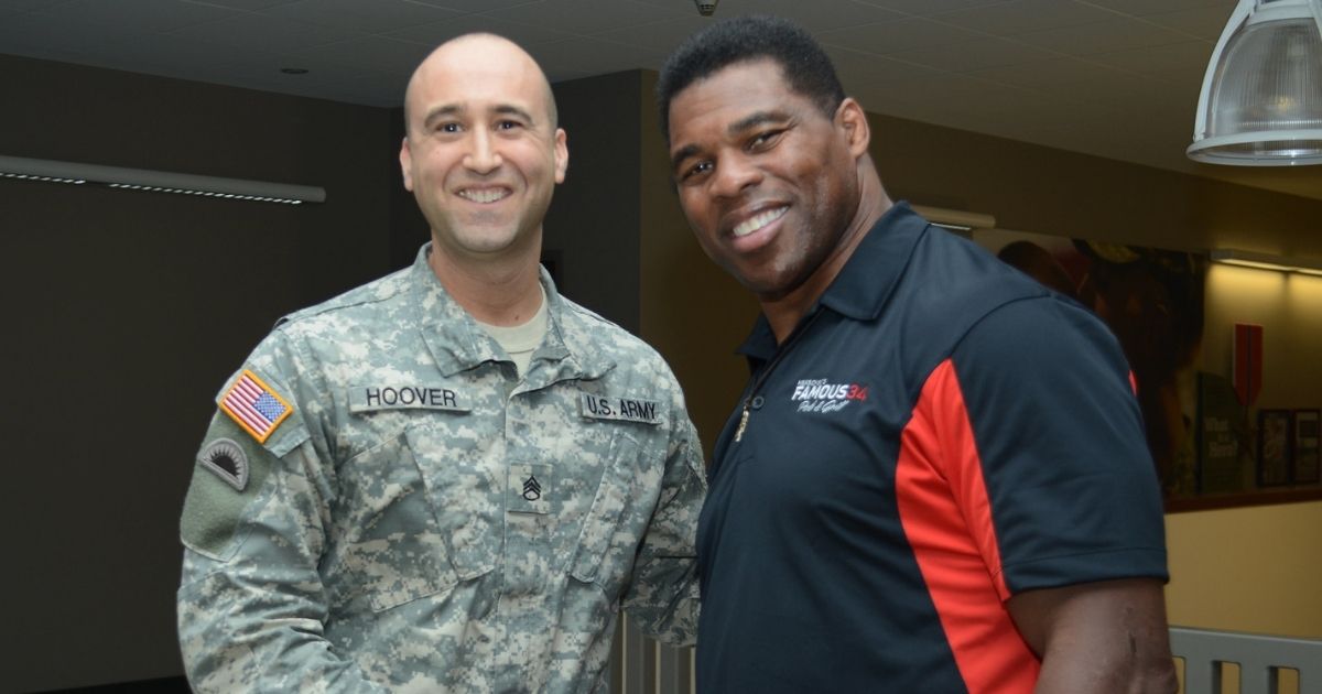 Herschel Walker shaking hands with a member of the National Guard