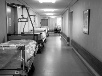 Hospital beds lined up in a hallway