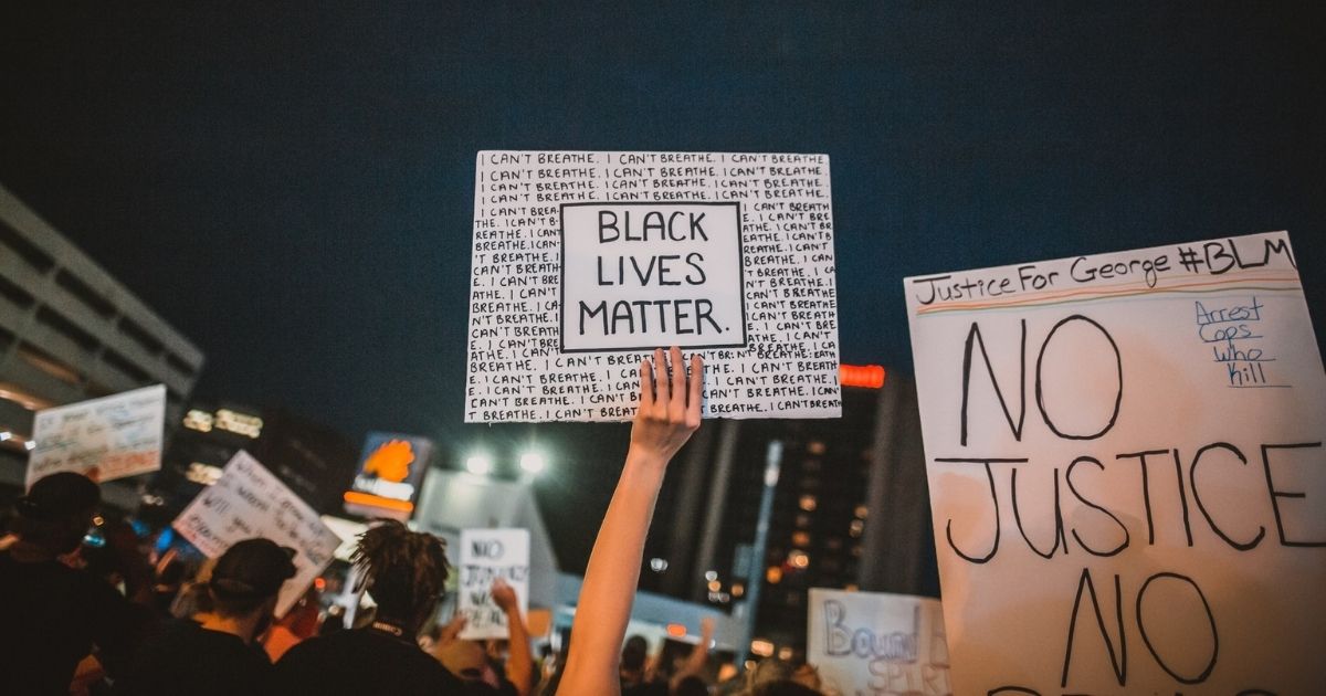 Rioters holding BLM and justice signs