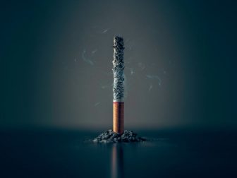 Burning cigarette against a dark background