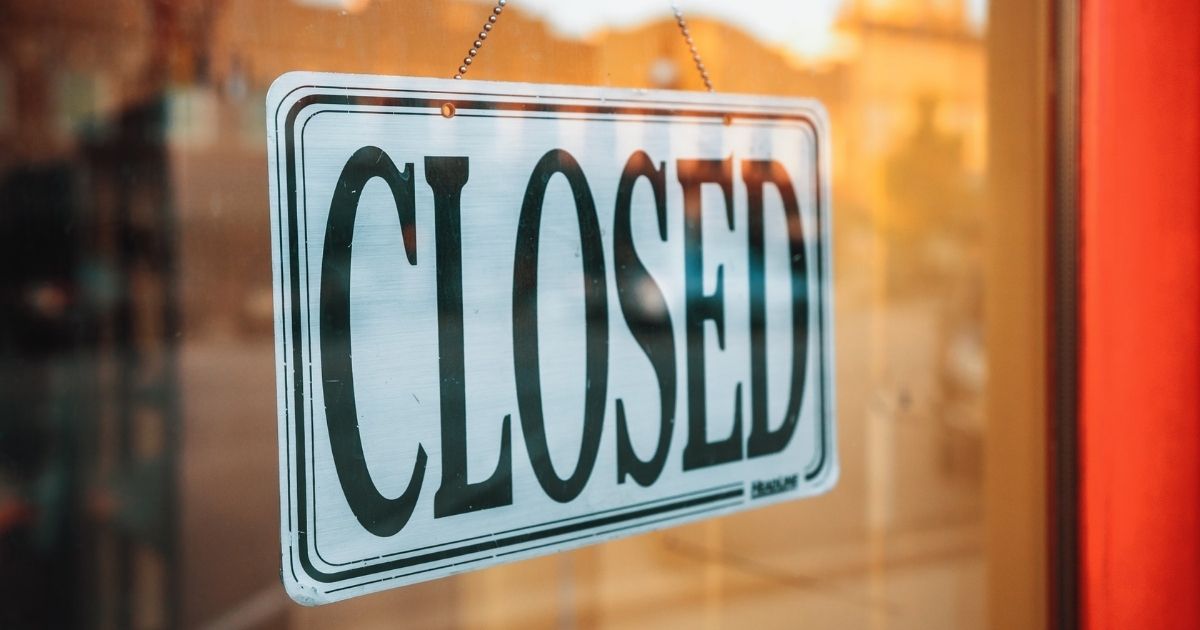 Closed sign hanging in a storefront