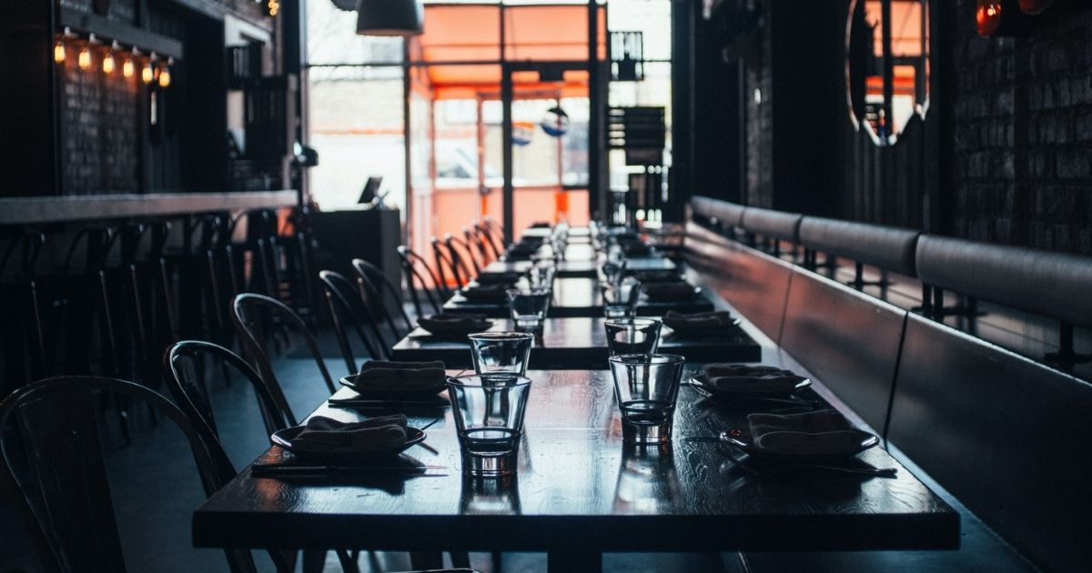 Set tables in a closed and darkened restaurant.