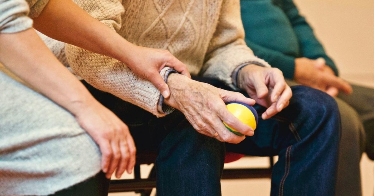 An elderly person holding a stress ball