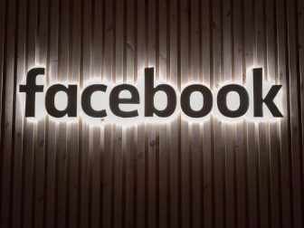 Facebook sign on a wood-paneled wall