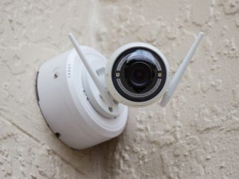 Security camera in the corner of a white wall