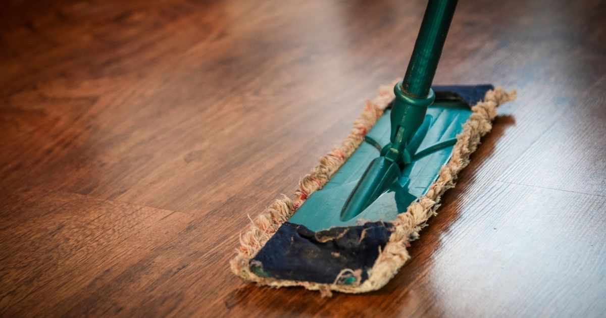 Green Swiffer on a wood floor.