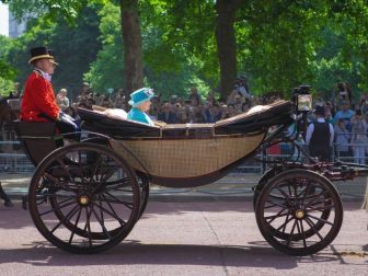 The queen of England riding in a carriage