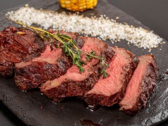 Grilled beef fillet steaks with herbs and spices on dark background