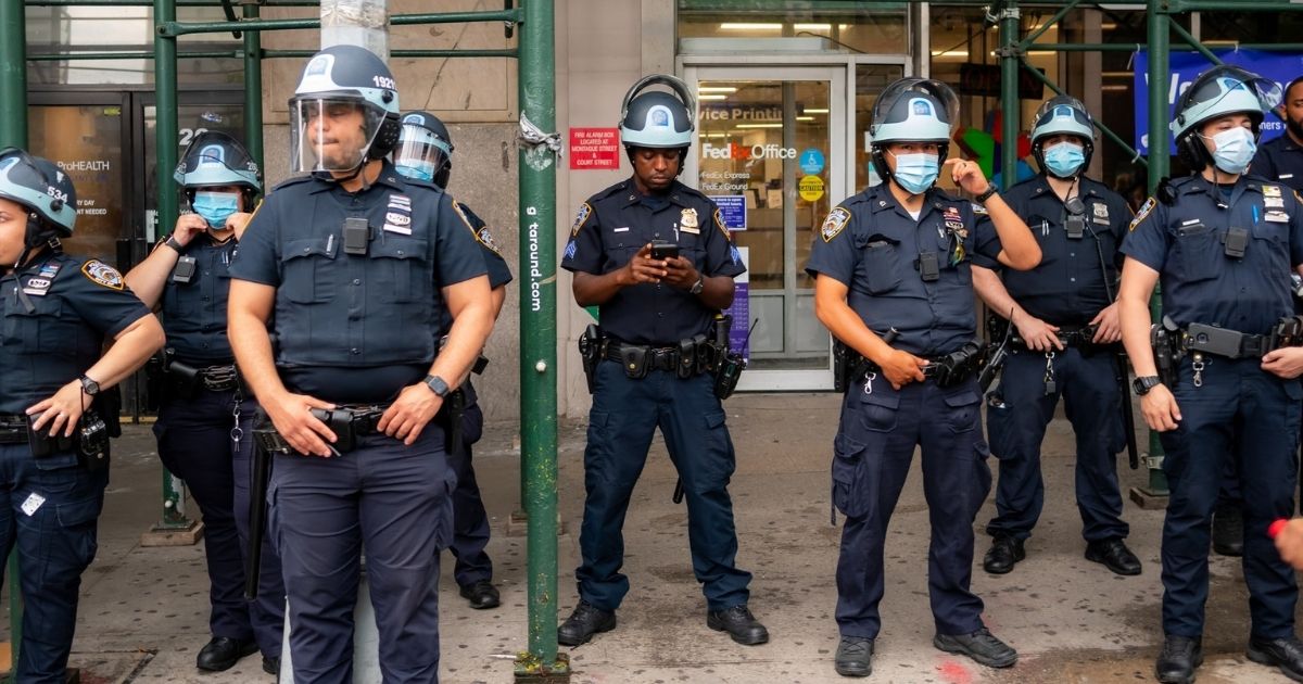 Police officers standing on a side walk under scaffolding