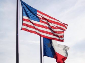 The United States flag flying above the Texas state flag