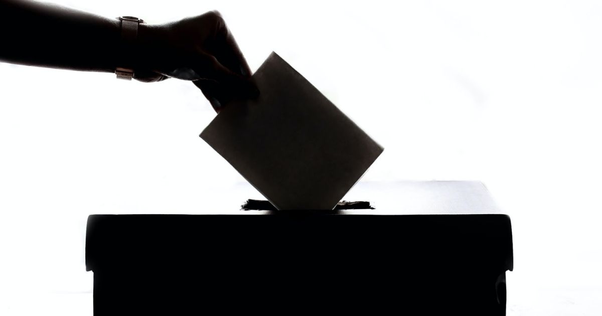 Silhouette of a hand putting an envelope into a box