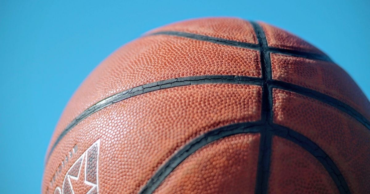 Brown basketball under a blue sky